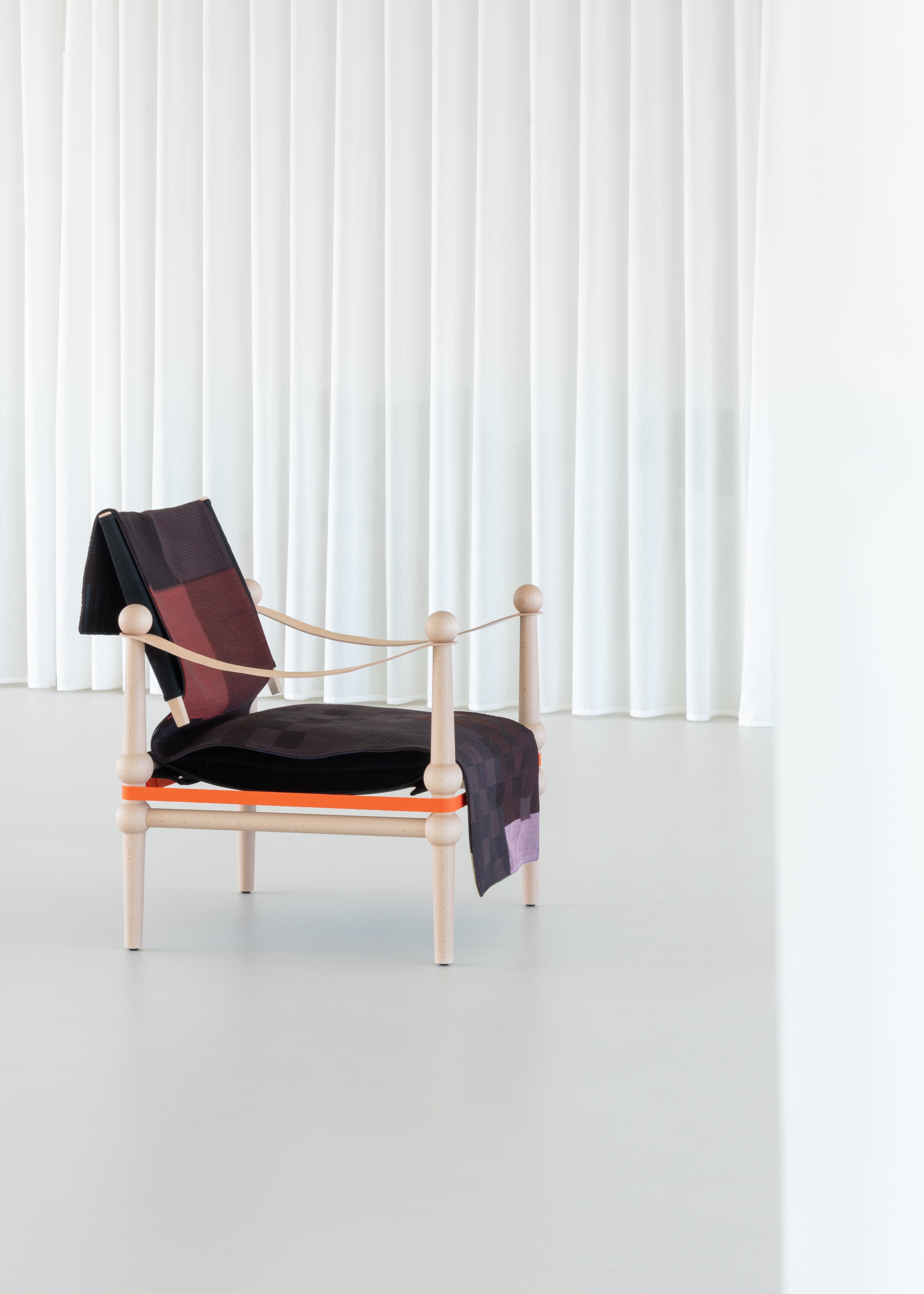 TWAIN armchair with a brown-purple blanket and a light beech base
