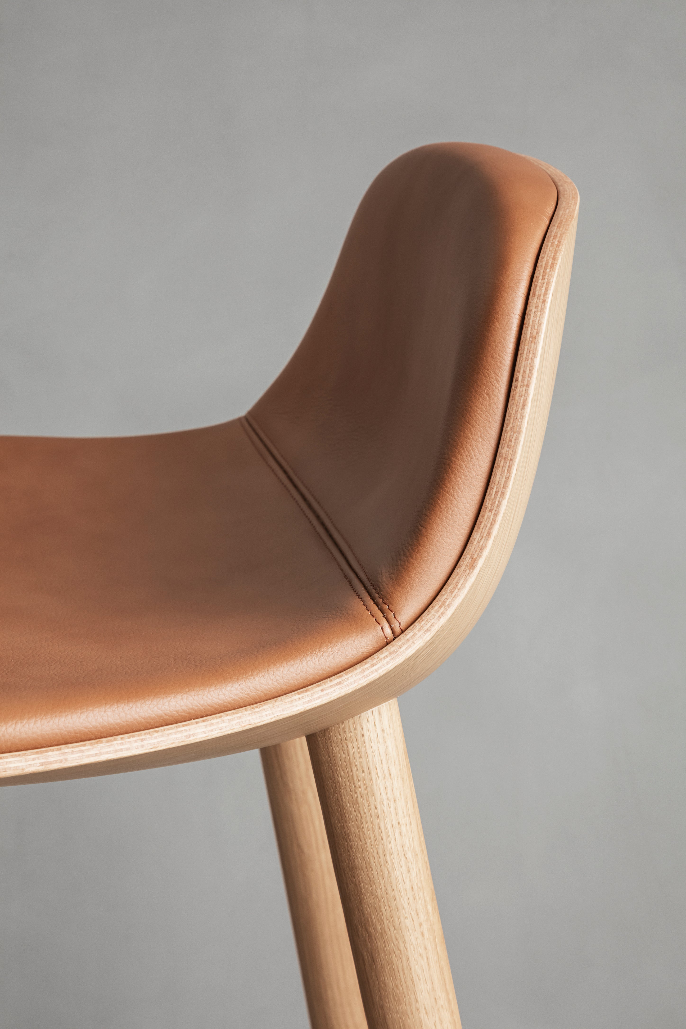 YUUGA stool in brown with a wooden base