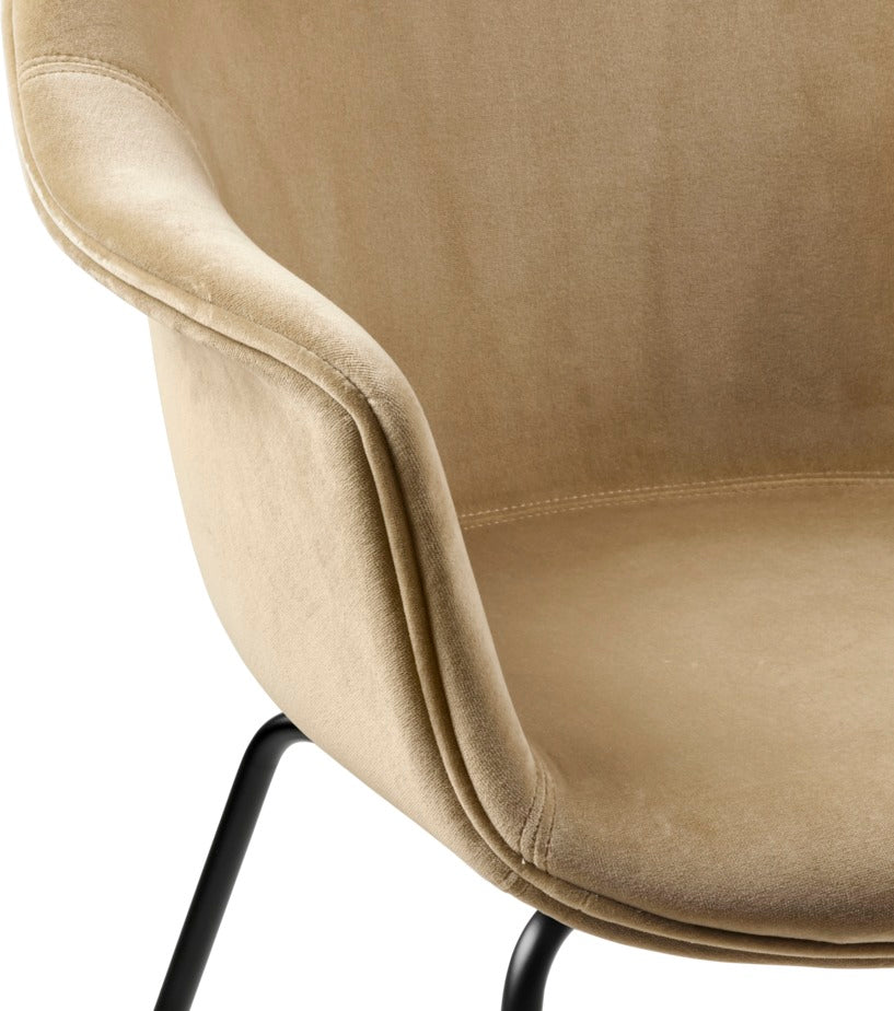 Upholstered BAT chair with a black metal base