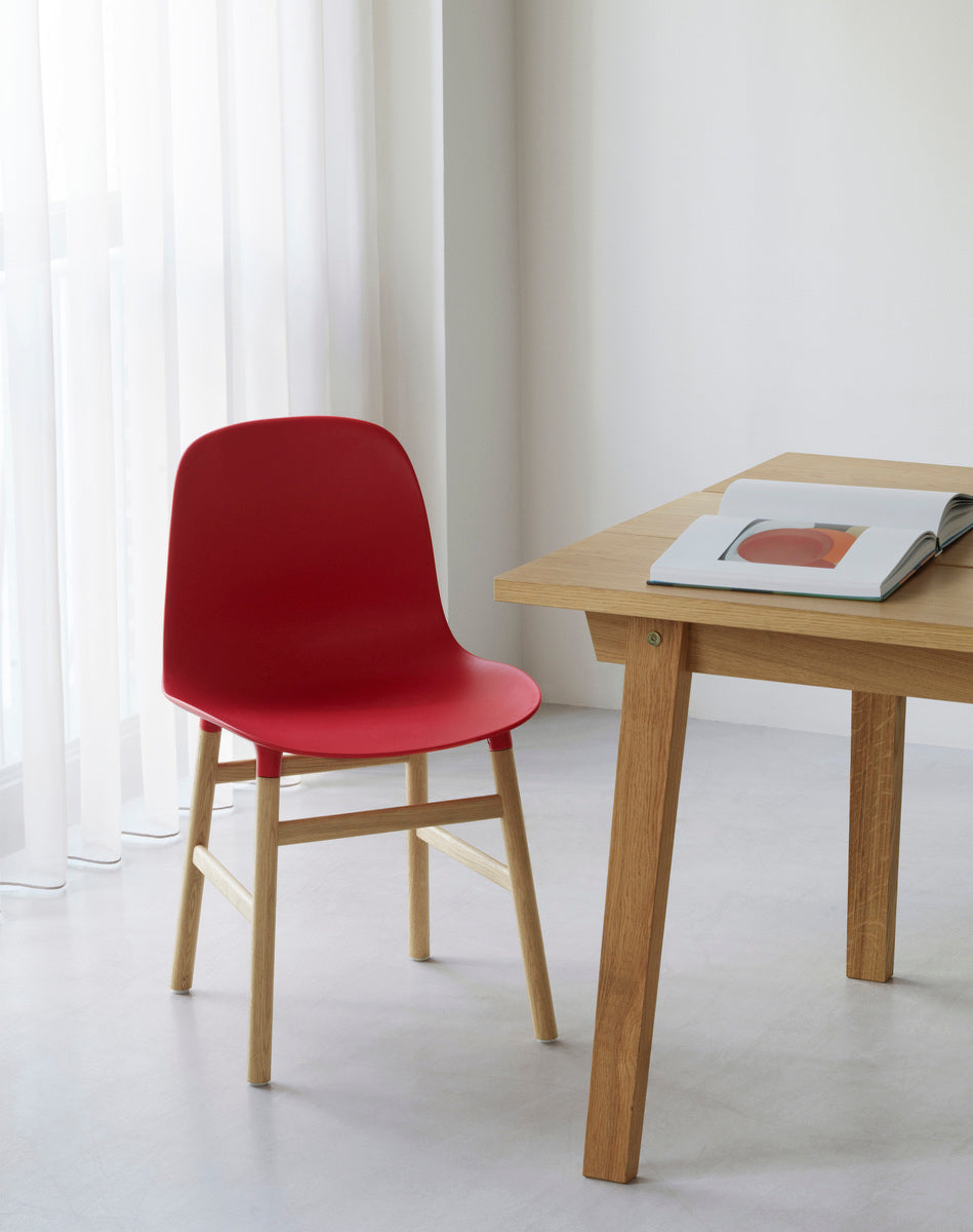 A chair of green forms with a black oak base