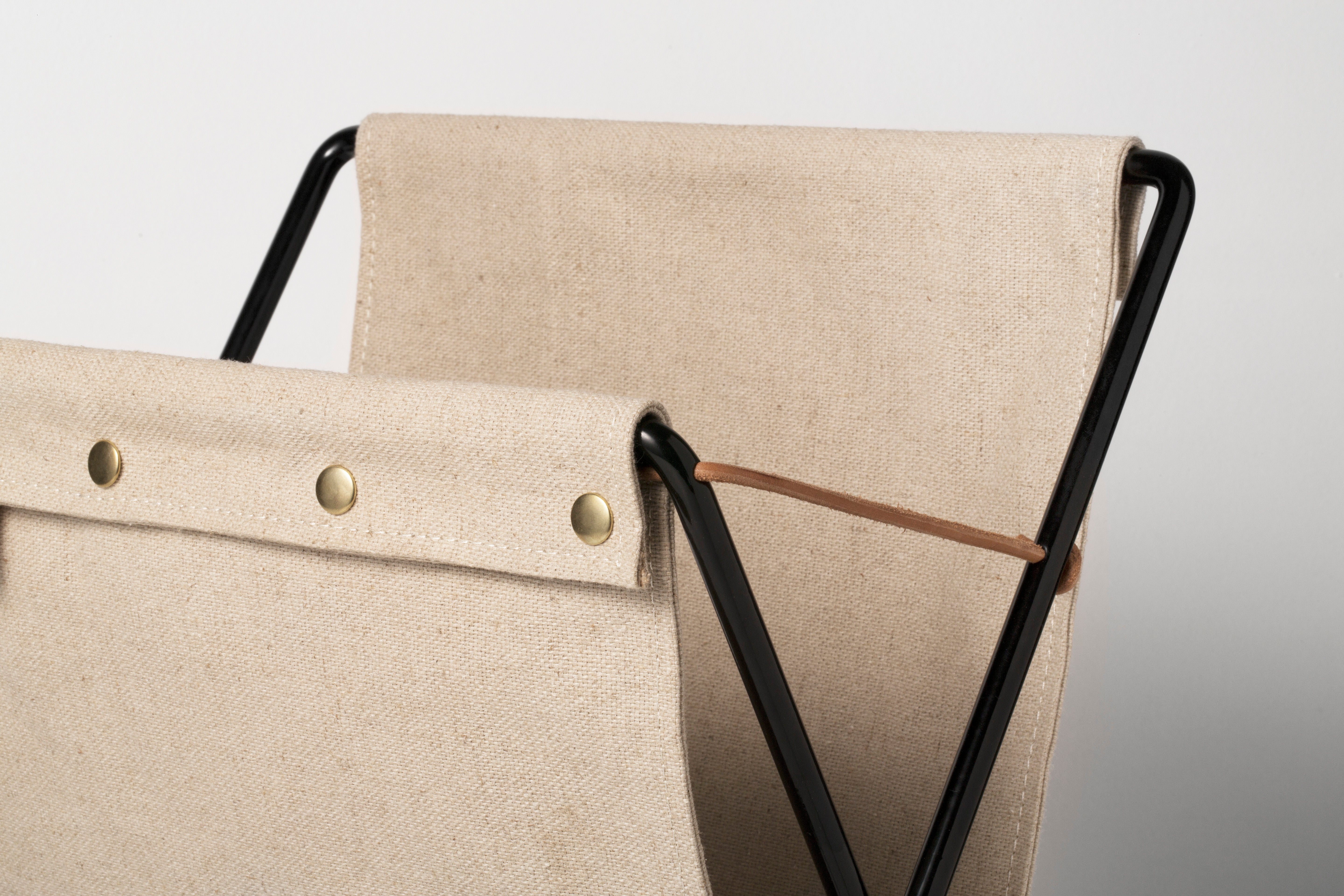 HERMAN beige magazine rack with a black base