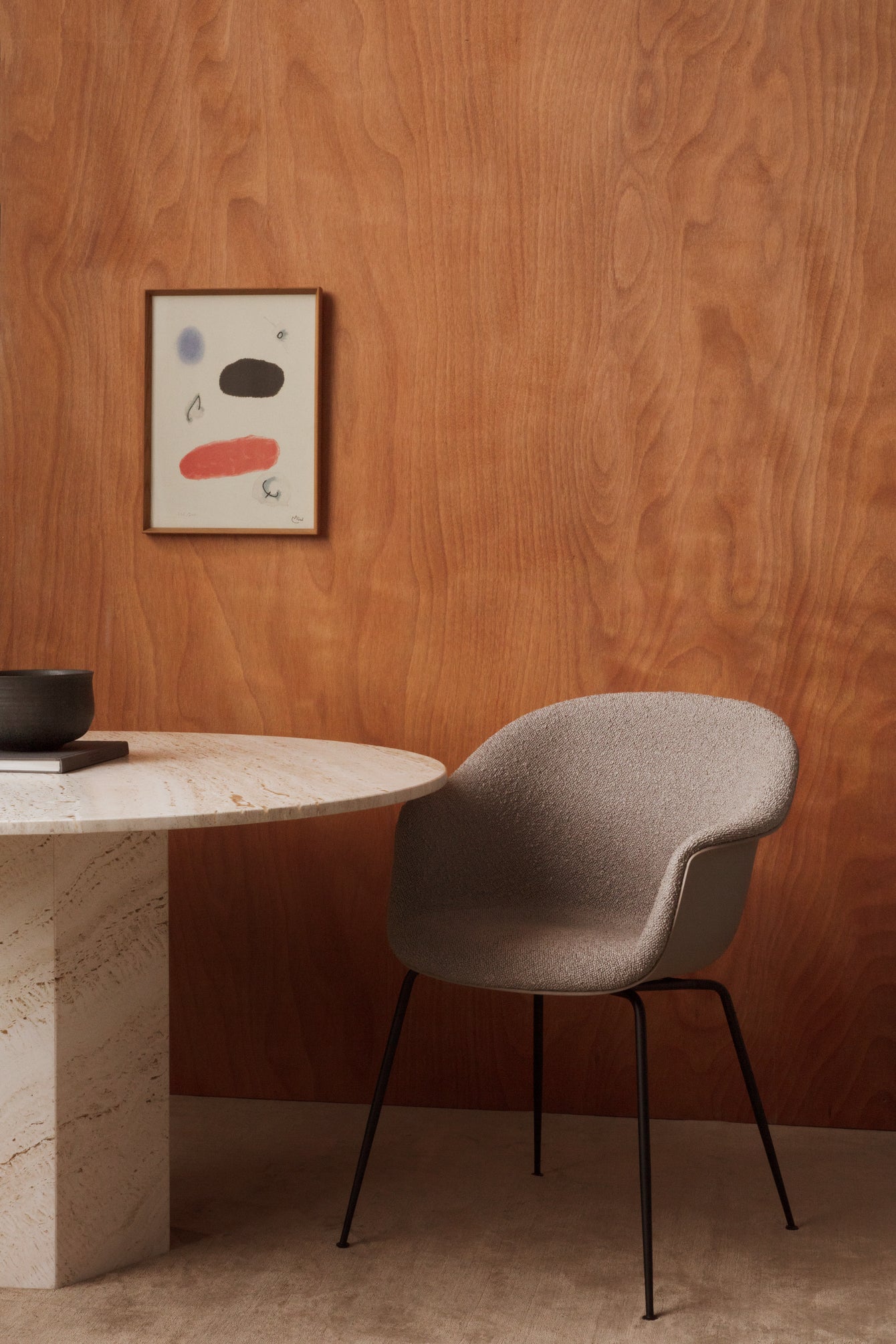 Upholstered BAT chair with a black metal base